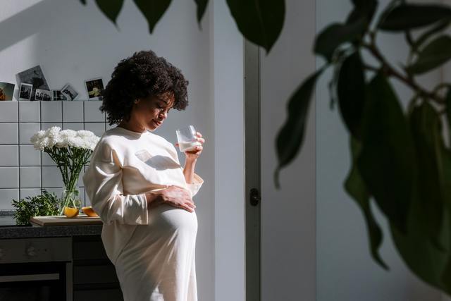 A surrogate holding a glass of water